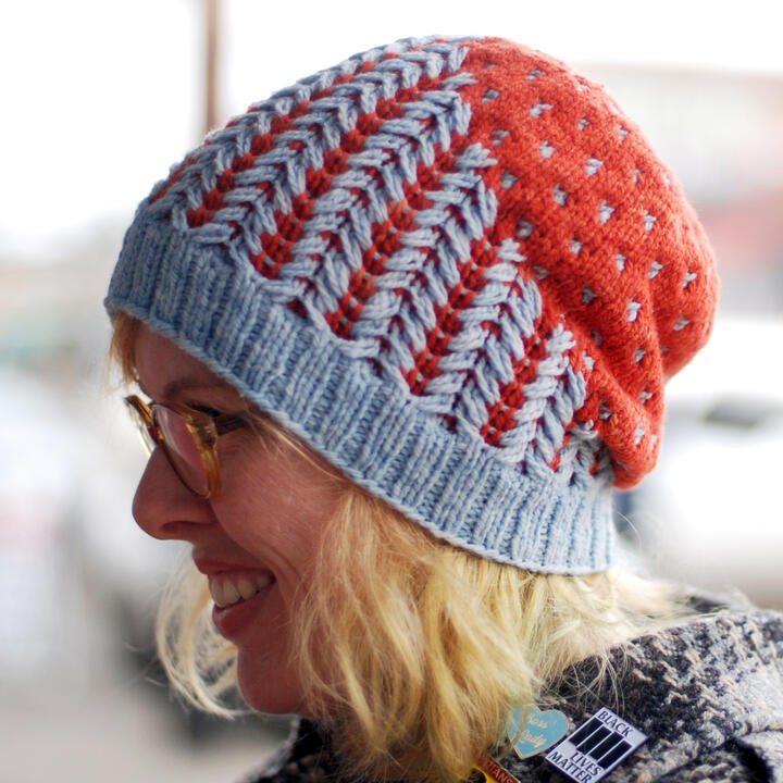 Lee wearing red and light blue slouchy hat with texture/color pattern