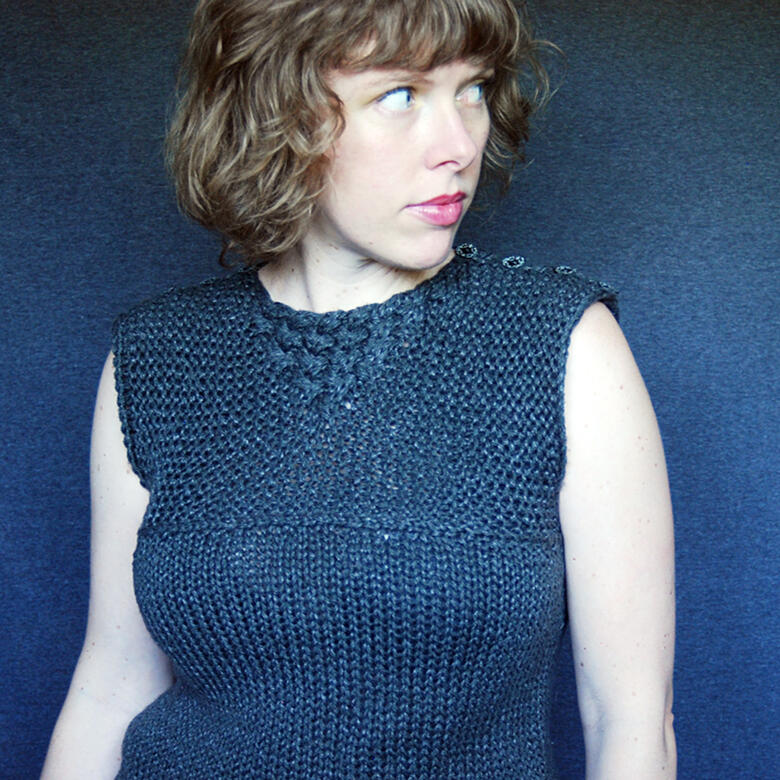 Lee wearing dark grey sleeveless top with textured/cabled top section