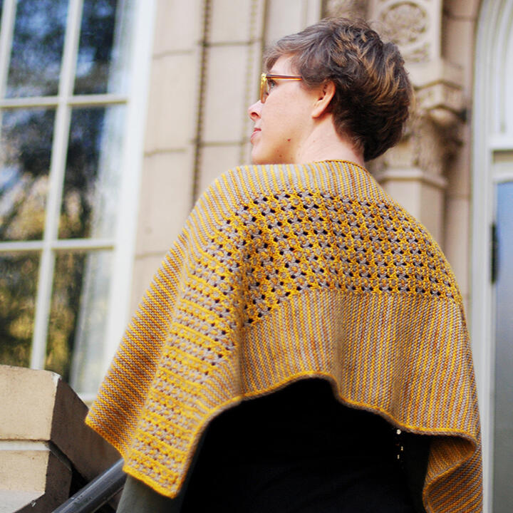 Lee wearing yellow and grey rectangular shawl/wrap